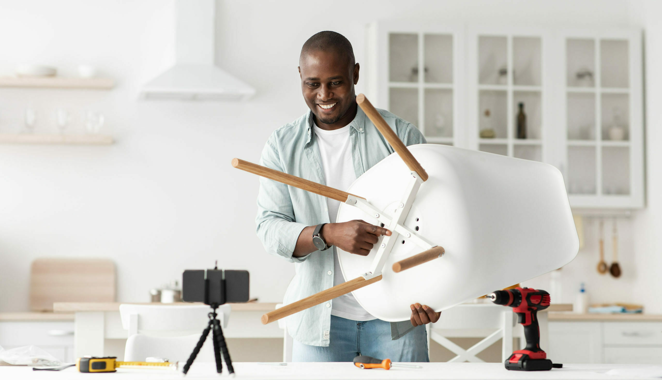Blog about carpentry and repairs. Positive african american handyman showing finished chair to