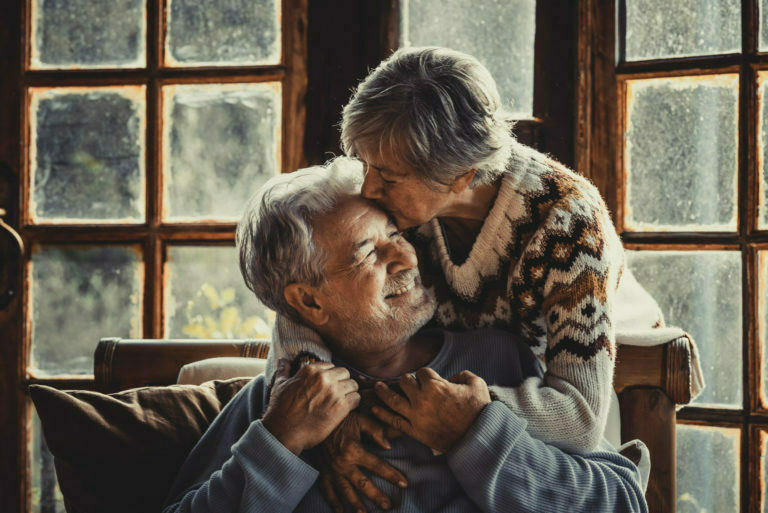 Senior people at home in love kissing and caring each other. Happy relationship mature couple